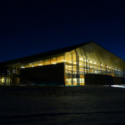 Installations d'éclairage pour grand format Halle de sport éclairée, vue de nuit, depuis l'extérieur